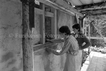 Restauration der Schmelzra, zwei Arbeiter passen Fenster ein