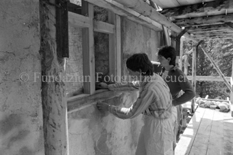 Restauration der Schmelzra, zwei Arbeiter passen Fenster ein