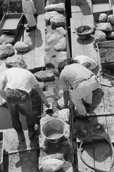 Restauration der Schmelzra, Arbeiter mit Mörtel und Steinen auf Holzgerüst beim Mauerbau