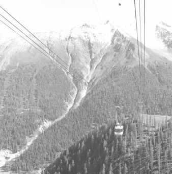 Luftseilbahngondel vor Berglandschaft