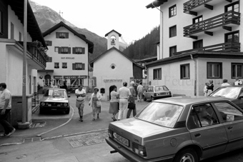 Dorfansicht, Personen und Autos vor Kapelle