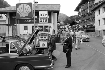 Personen und Autos an Tankstelle