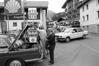 Personen und Autos an Tankstelle