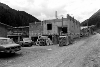 Autos vor Baustelle, unverputzte Mauern