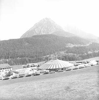 Zelte des Zirkus Nock auf Feld vor Wald und Berglandschaft, im Hintergrund Vulpera