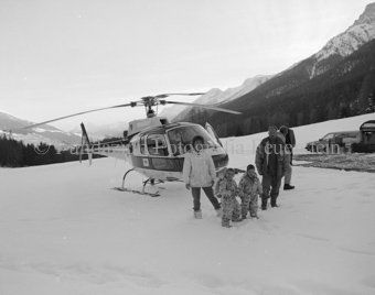 Familie vor Helikopter im Schneefeld
