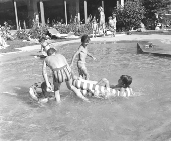 Kinder in Badekleidung in flachem Pool bei Sportanlage Trü