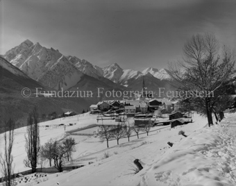 Blick auf Dorf Sent und Berglandschaft im Winter
