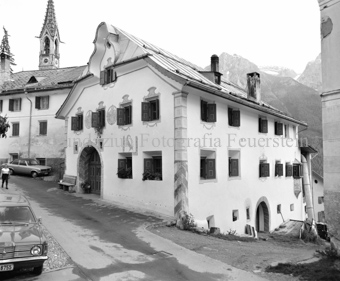 Haus mit Sgraffito im Dorf, im Hintergrund neugotischer Kirchturm
