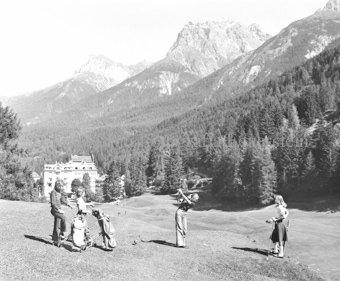 Personen beim Golfabschlag, Vulpera im Hintergrund