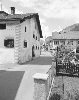 Gasse im Dorf mit Blick auf Kirche, Fassade mit Sgraffito