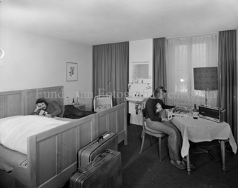 Innenaufnahme, Zimmer, Frau am Tisch, Mann auf Bett, Hotel Quellenhof