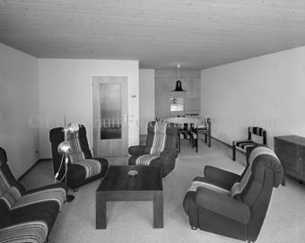 Innenaufnahme, Zimmer, vier Sessel im Kreis, im Hintergrund Tisch mit Stühlen