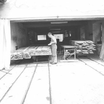 Mann mit zugeschnittenen Brettern im Sägewerk