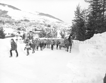 L'Hom Strom, Kinder und Pferdegespann transportieren Strohmann durch Schnee