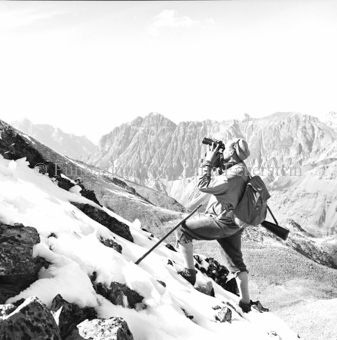 Jäger mit Gewehr und Fernglas, Berglandschaft im Hintergrund