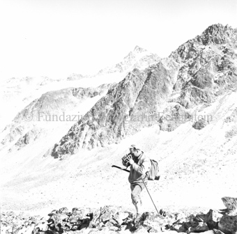 Jäger mit Gewehr und Fernglas, Berglandschaft im Hintergrund