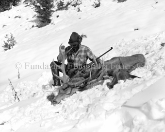 Jäger mit geschossenen Hirschbock und Hirschkuh im Schnee