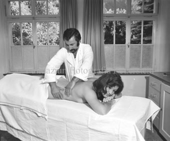 Masseur mit Frau auf der Liege in Kurhotel
