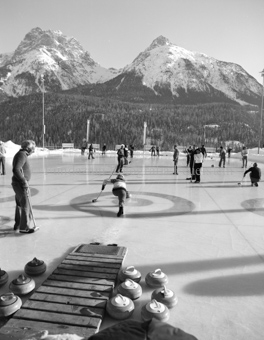 Personen beim Curlingspiel bei Sportanlage Trü, Berglandschaft im Hintergrund