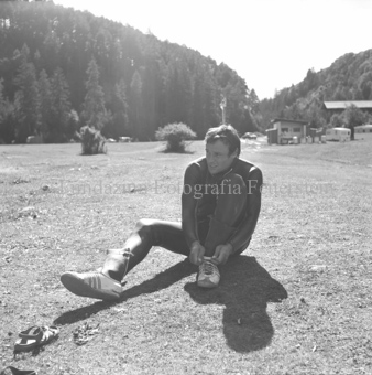 Mann in Trockenanzug zieht Schuhe mit Stulpen an