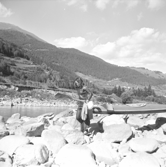 Frau in Trockenanzug trägt Kanu zum Inn