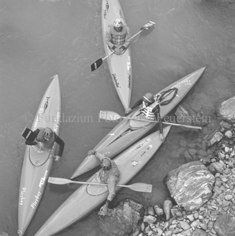 Vier Personen in Kanus auf dem Inn am Ufer