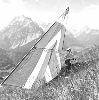 Hängegleiterflieger auf Wiese, Bergauf gehend