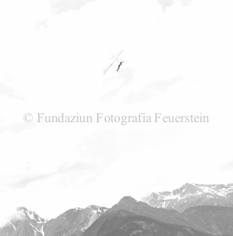 Hängegleiterflieger in der Luft, Berge im Hintergrund