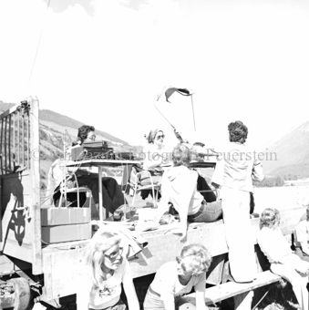 Personen auf Tribüne mit Geräten auf Tisch