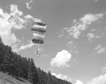 Gleitschirmflieger in der Luft, Wald im Hintergrund