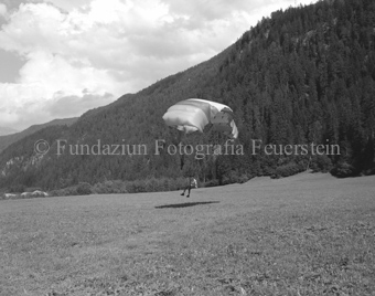 Gleitschirmflieger bei der Landung, Wald im Hintergrund