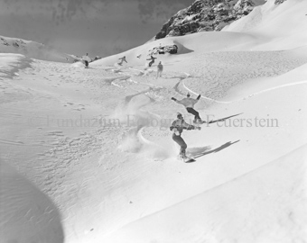 Snowboardergruppe im Slalom den Hang herunter
