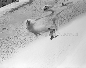 Snowboardergruppe im Slalom den Hang herunter