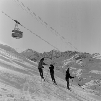 Drei Skifahrer mit Seilbahn