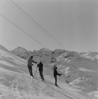 Drei Skifahrer mit Seilbahn