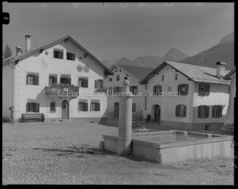 Dorfplatz Scuol mit Brunnen und Häuser