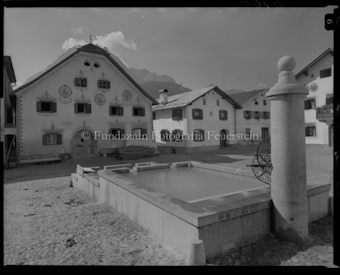 Dorfplatz Scuol mit Brunnen und Häuser