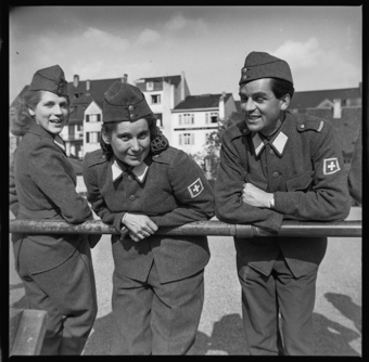 Lachende Frauen und Mann in Uniformen während einer Pause
