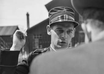 Polizeibeamter mit Bleistift konzentriert sich auf die Einvernahme einer Person