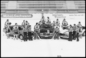 Gruppenfoto der Eishockeymannschaft vom Schlittschuh-Club Bern mit Autos auf dem Eisfeld