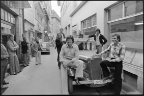 Roland Dellsperger und René Berthod (vorne auf dem Auto sitzend) eröffnen im Ryffligässli eine Bar (Sportler-Treffpunkt, auf dem Bild u.a. Bernhard Russi als Ehrengast