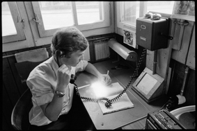 Bahnwärter bei der Arbeit mit Telefon und Notizbuch