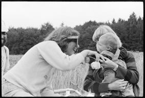 Velofahrerin begrüsst Frau mit Kleinkind