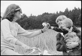 Velofahrerin begrüsst Frau mit Kleinkind