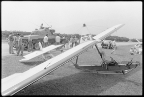 einplätziges Flugzeug F-AZBJ am Boden stehend, daneben Auto mit französichem Kennzeichen, dahinter ein Panzer