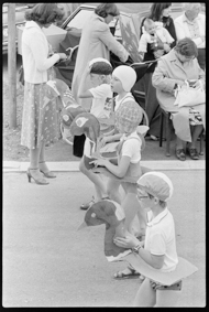 Umzug mit Kindern in Badekleidern und Schwimmringen aus Karton