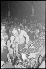 Tontechniker oder Redner an Mischpult und Aufnahmegerät, im Hintergrund zahlreiche Besucherinnen und Besucher des Anlasses