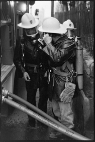 Feuerwehrmänner mit Gasmasken bei der Arbeit neben Tankwagen, Schläuche mit Aufschrift Ostermundigen