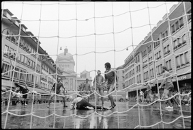 Fussballszene vor dem Tor, im Hintergrund die «Front» (Häuserzeile mit Restaurants) und das Bundeshaus